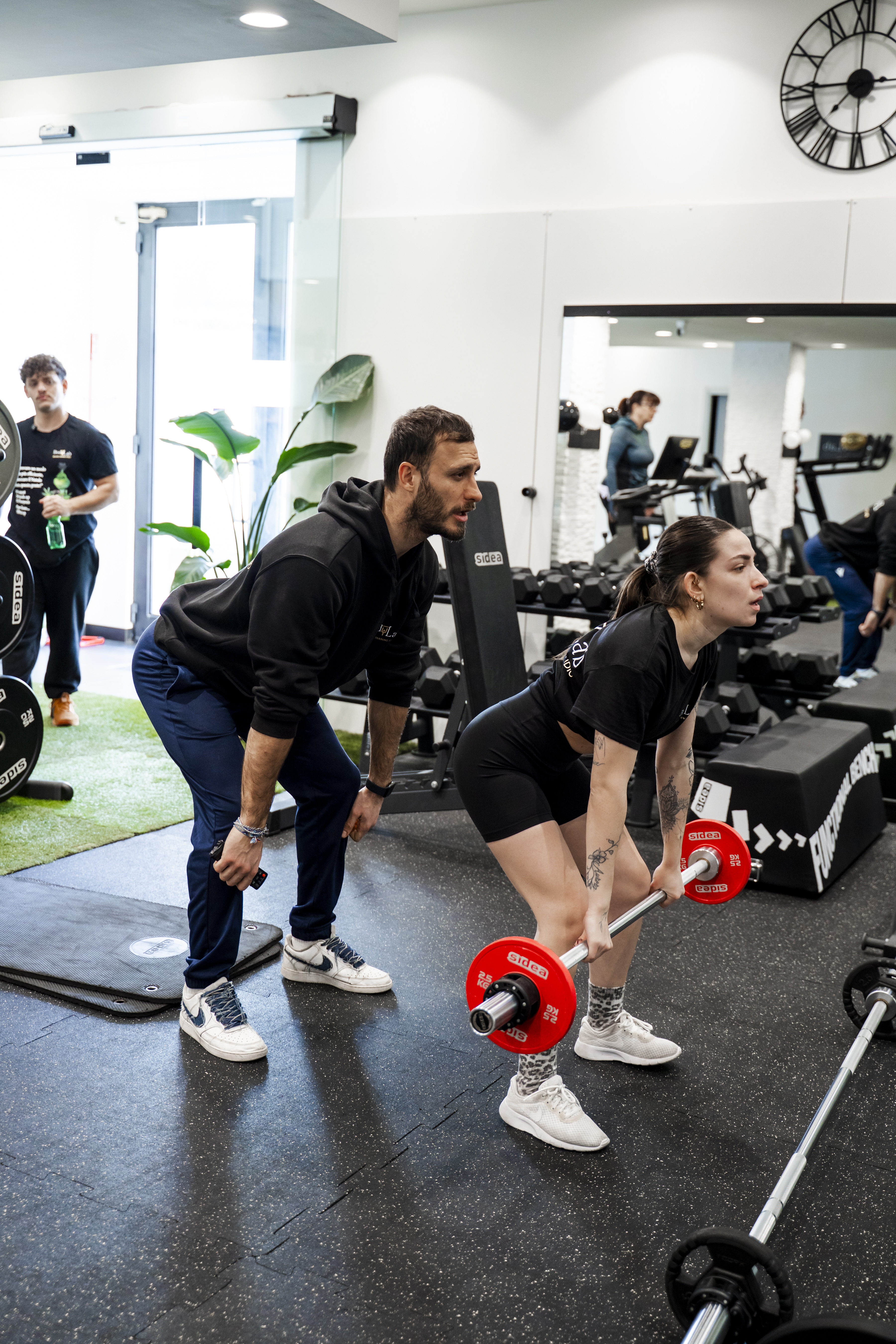 Personal trainer che segue un allenamento uno a uno in studio